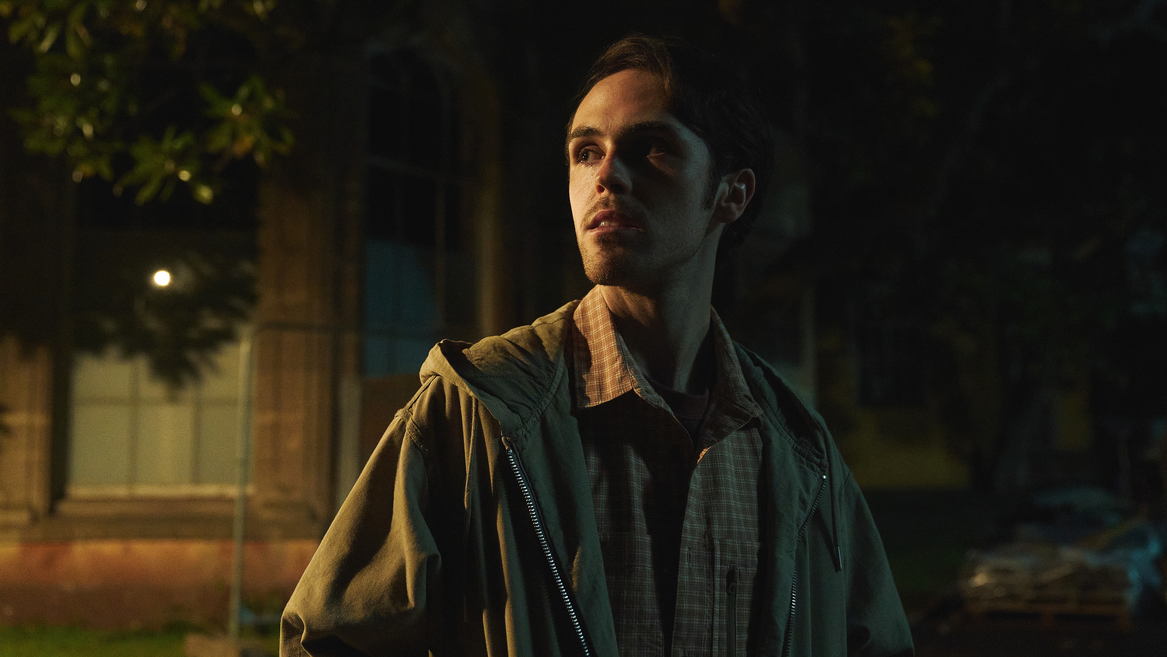 Stanley (MISIA BUTLER) standing in a dark street looking serious