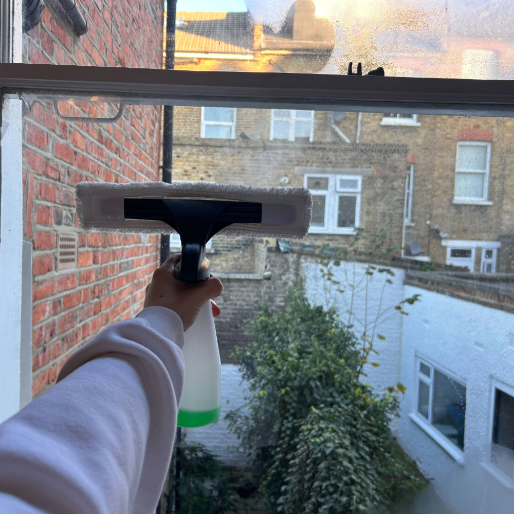 Megan holding the Daewoo spray bottle and cloth on her window