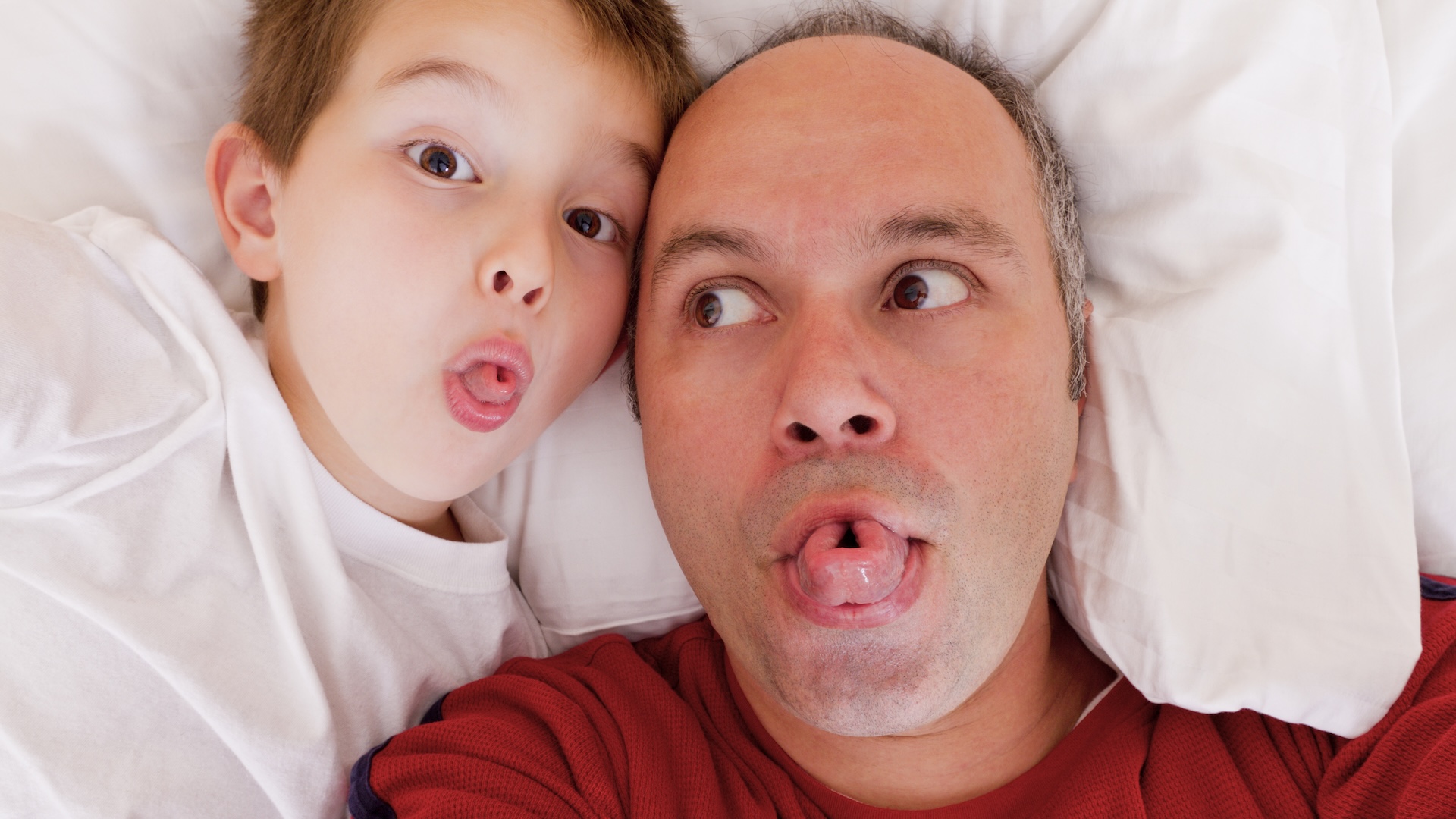 A selfie photo of a father and son rolling their tongues