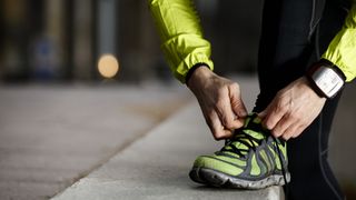 A runner lacing up his shoes