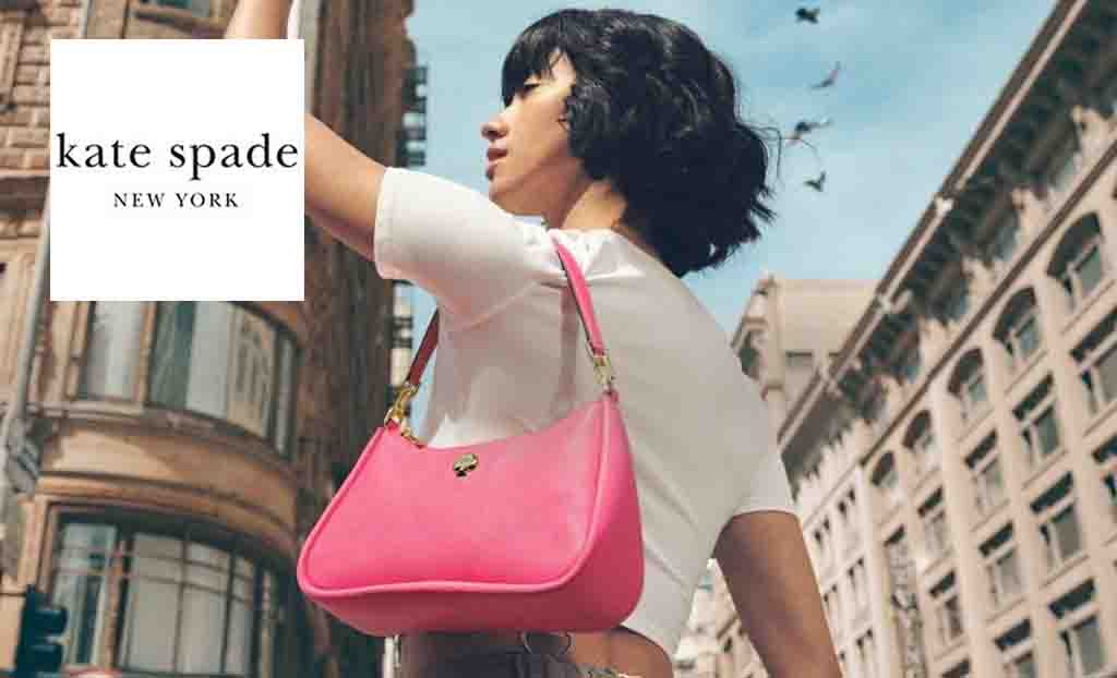 kate spade logo top left with a low angle shot of a woman wearing a small bright pink bag in a city