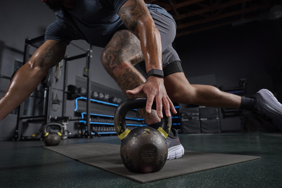 The Amazfit Helio Strap in black on a model's wrist during a workout.