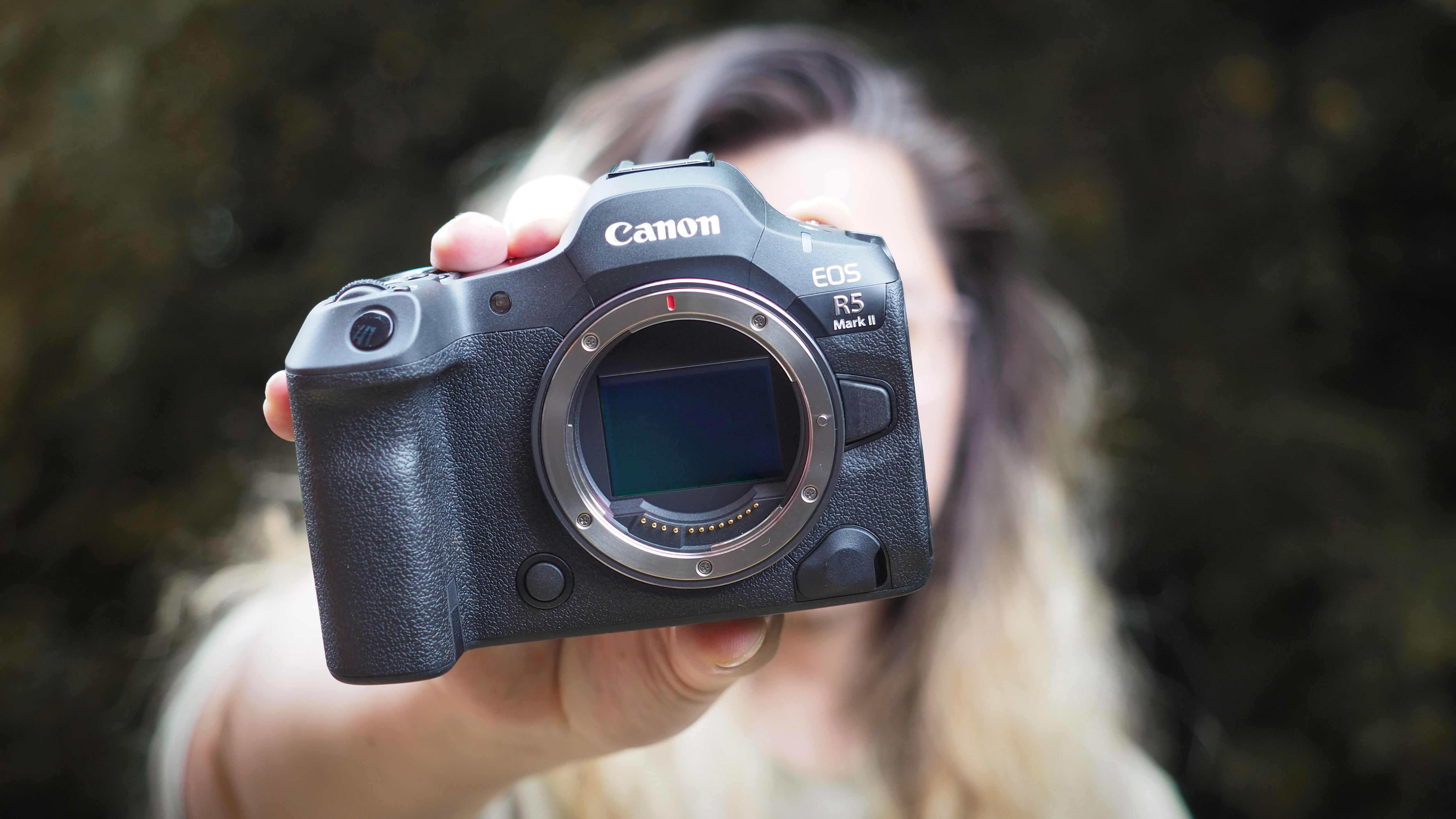 Canon EOS R5 Mark II being held out in front of a photographer&#039;s face, outdoors