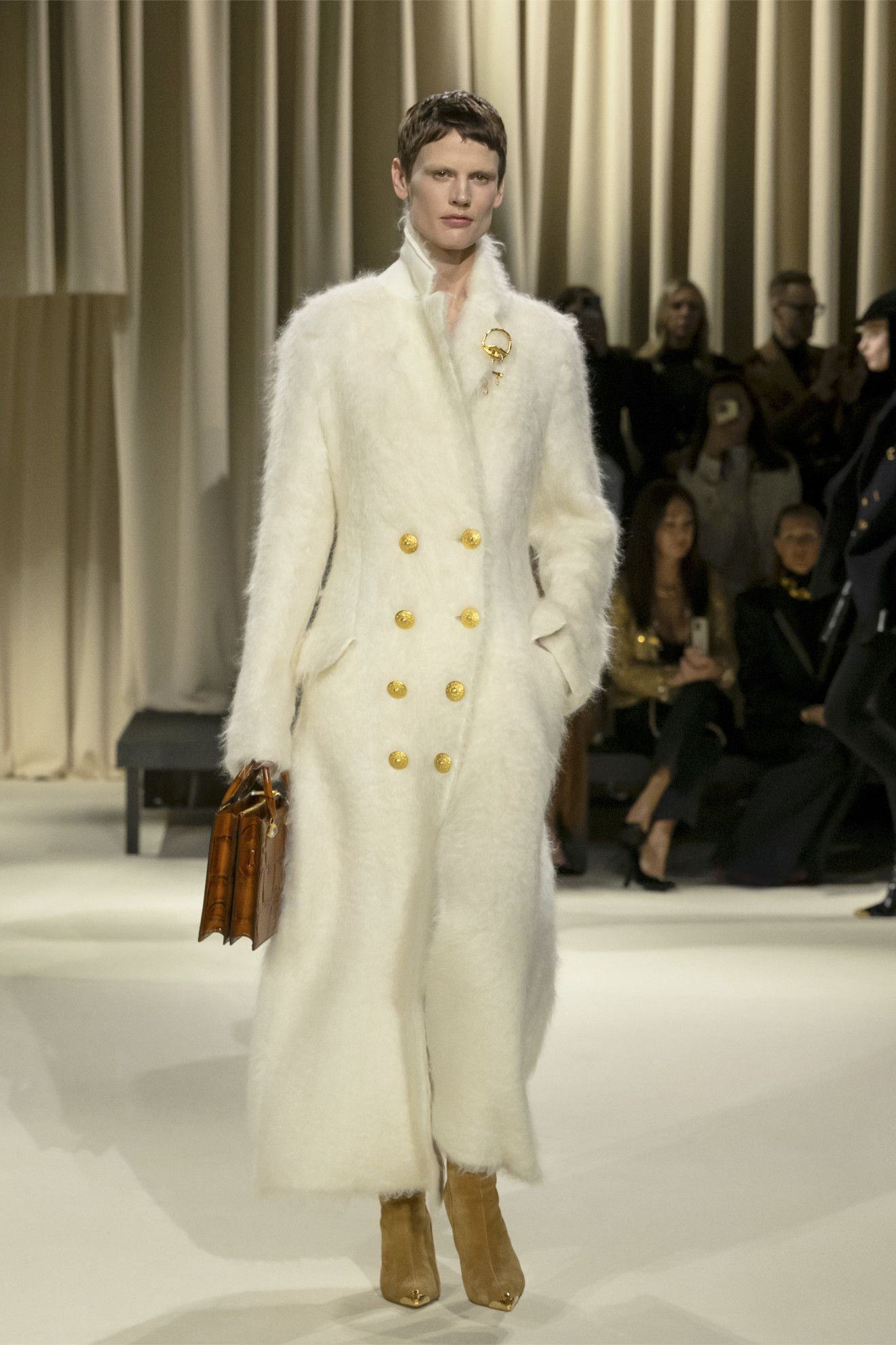 models wearing brooches on the runway