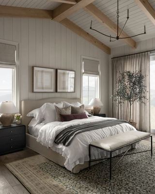 white bedroom with light grey bed styled with cushions