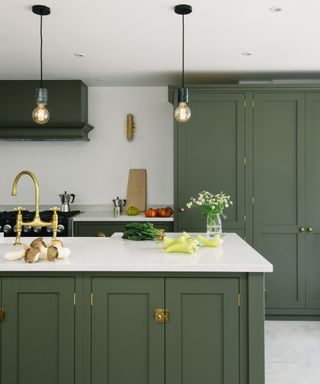 Olive green kitchen cabinets with white walls and white counters