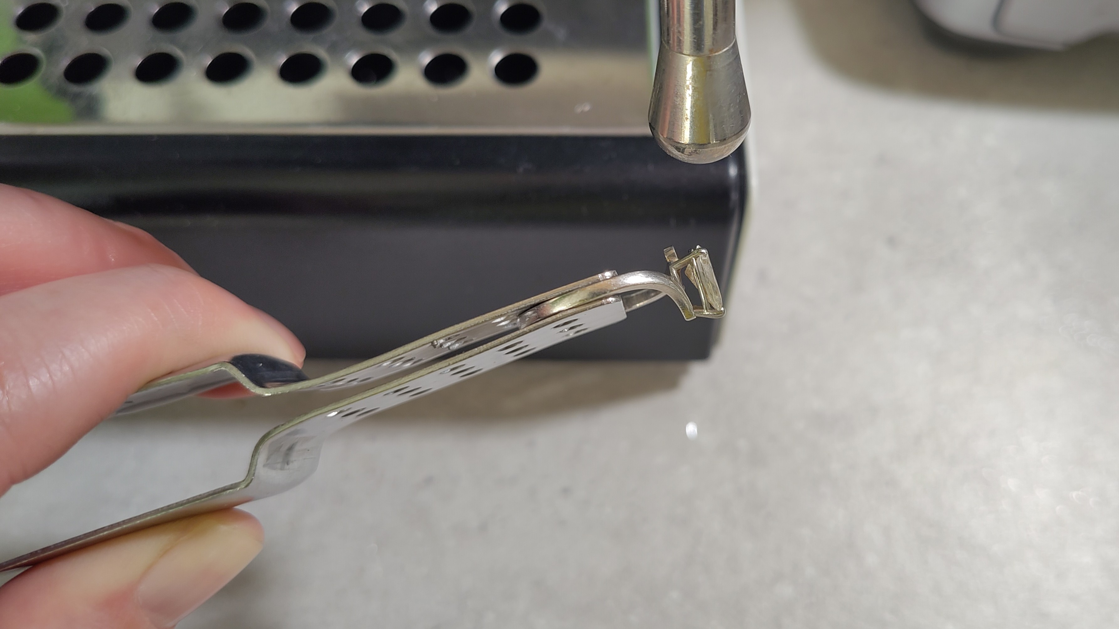 Person holding diamond ring near coffee maker