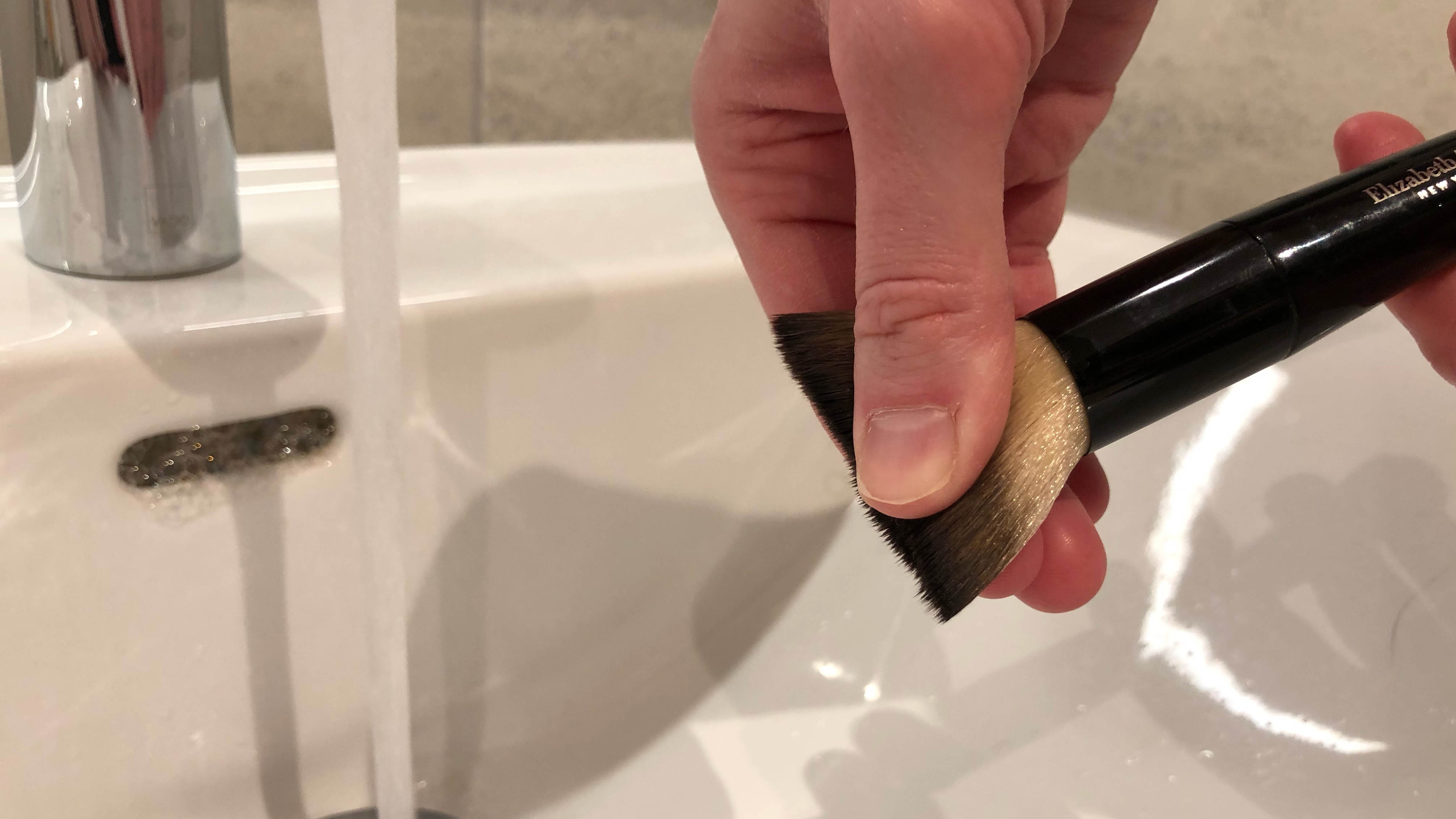 The water being squeezed from the makeup brush bristles