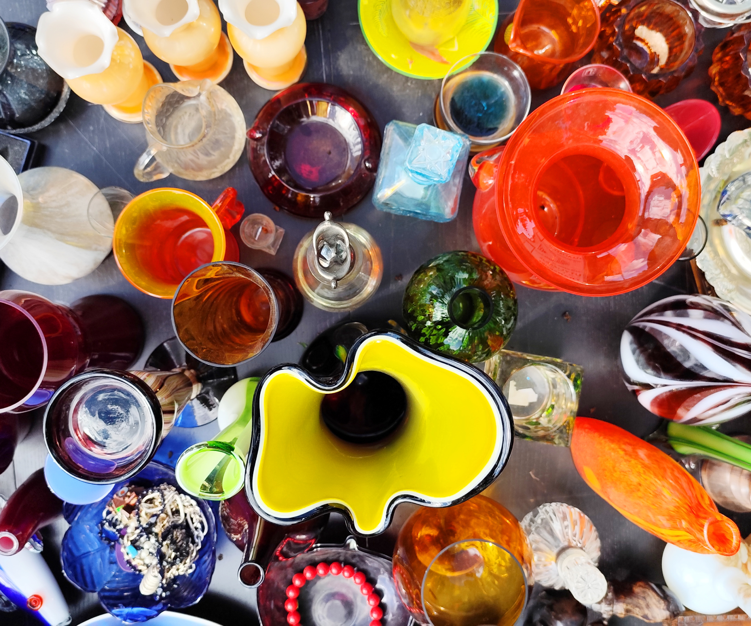 collection of colourful glass jars and vases on table