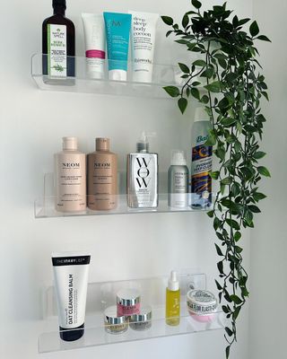 Acrylic shelves in bathroom holding beauty products