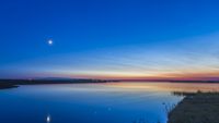 night sky at twlight with moon to the left and two bright points of light in the center of the sky, venus is on the right and jupiter the left