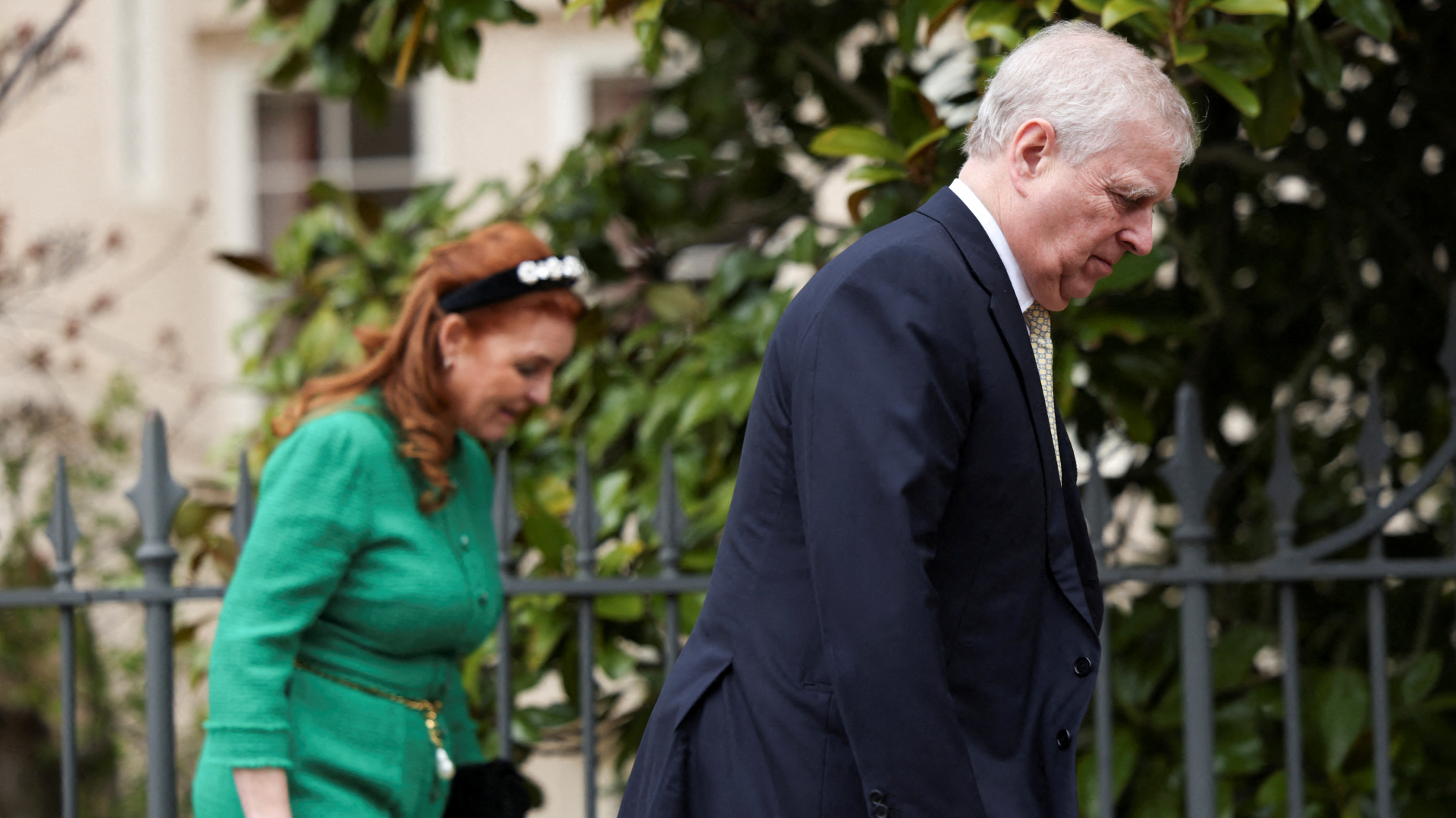 Sarah Ferguson wearing a green suit walking behind andrew Mountbatten-Windsor
