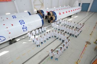 Rocket engineers arranged to represent a '50' in front of the components for the 50th Long March 2D.