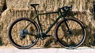 Best gravel race bikes: A Basso Palta II in green pictured in front of hay bales