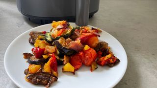 Mediterranean vegetables on a plate in front of the Cosori Lite Air Fryer