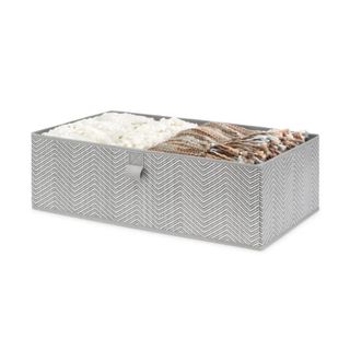 A gray and white storage bin with clothes