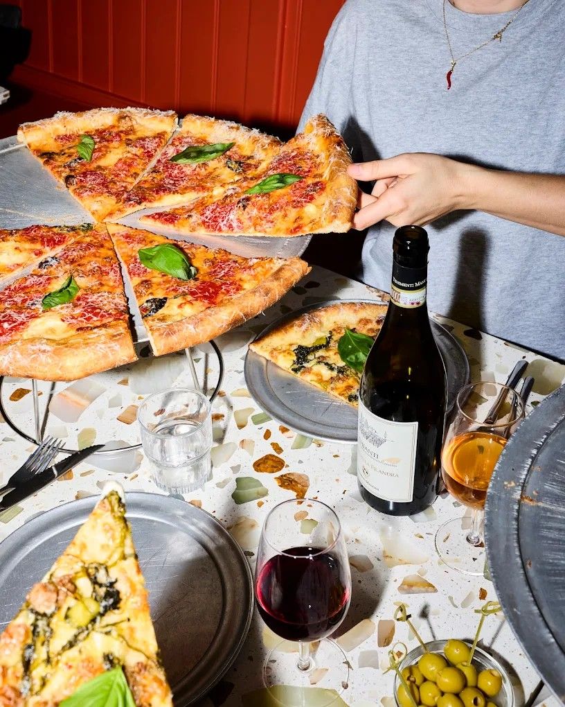 Flashed-out pictures depicting a pizzeria table covered in pizzas plated in chrome plates, and vintage icecream cups held by a waiter.
