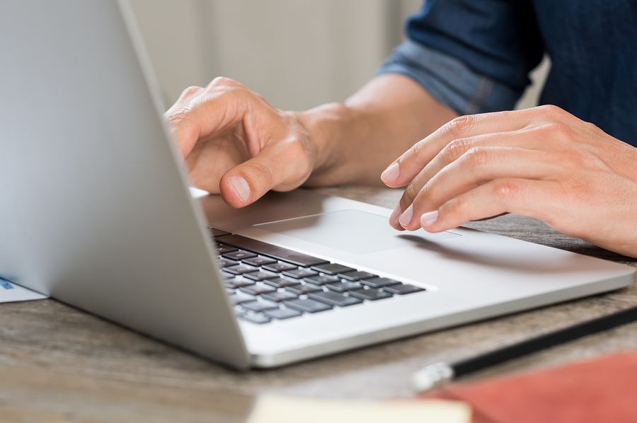 Close-up of a small business employee using a laptop on a table