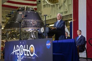 Vice President Mike Pence gives remarks on the 50th anniversary of the Apollo 11 moon landing near NASA's Artemis 1 Orion spacecraft (background) at the Kennedy Space Center’s Neil Armstrong Operations & Checkout Building on July 20, 2019.