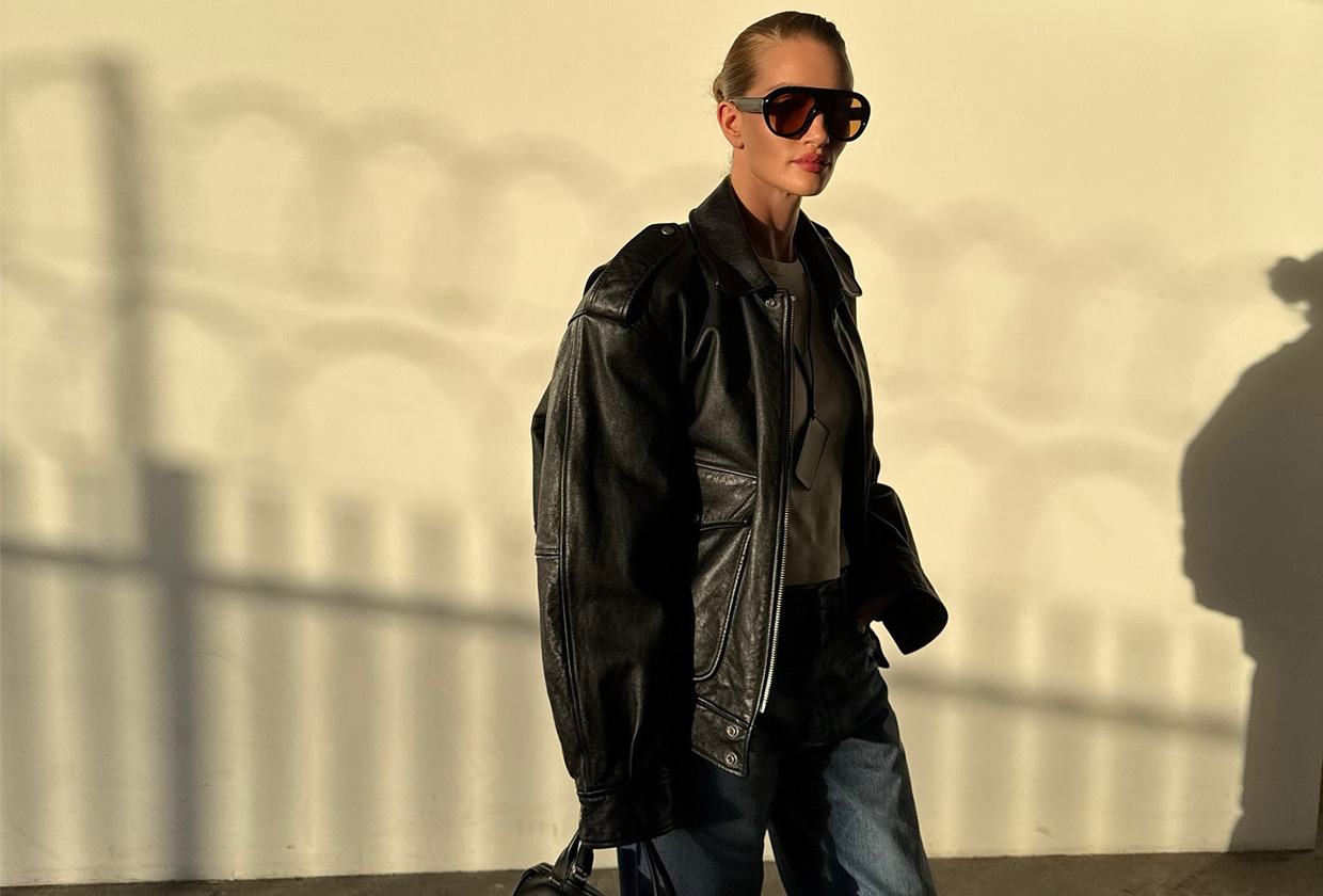 Rosie wears large sunglasses, a leather coat, and jeans.