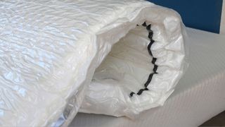 Mattress wrapped in plastic packaging before expanding.