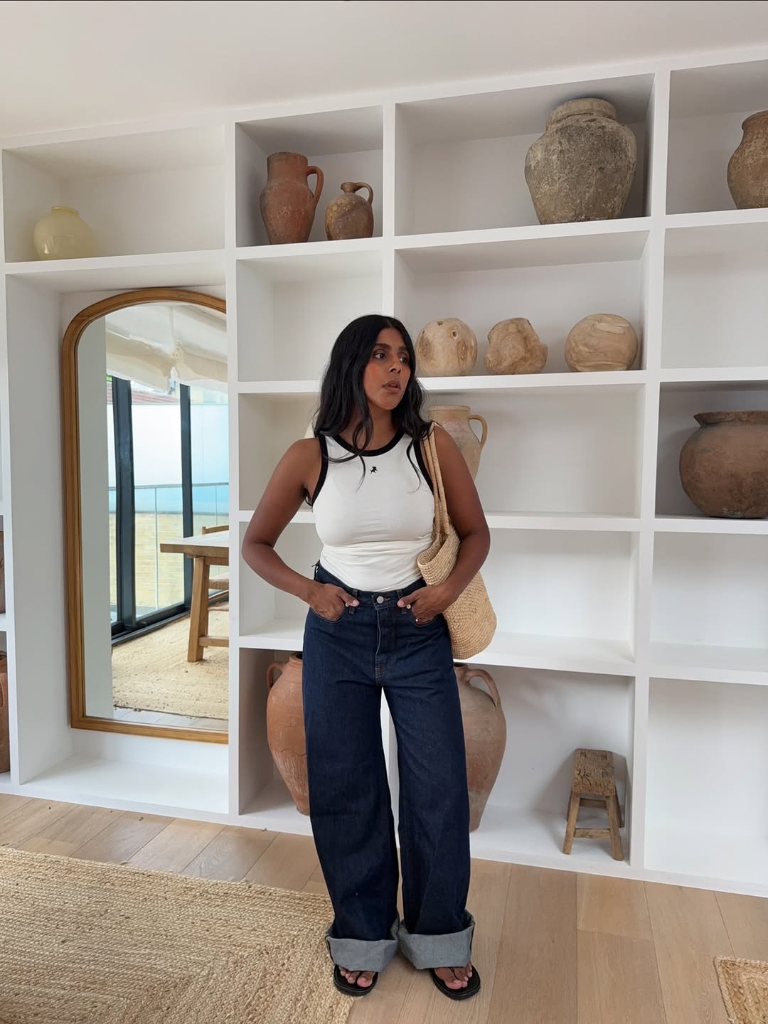 Monikh in indigo trousers and white vest