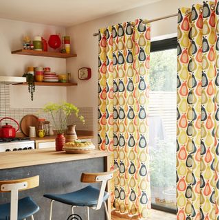 Patterned curtains hanging in front of kitchen window