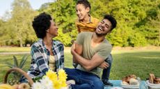 Family laughing at picnic in park