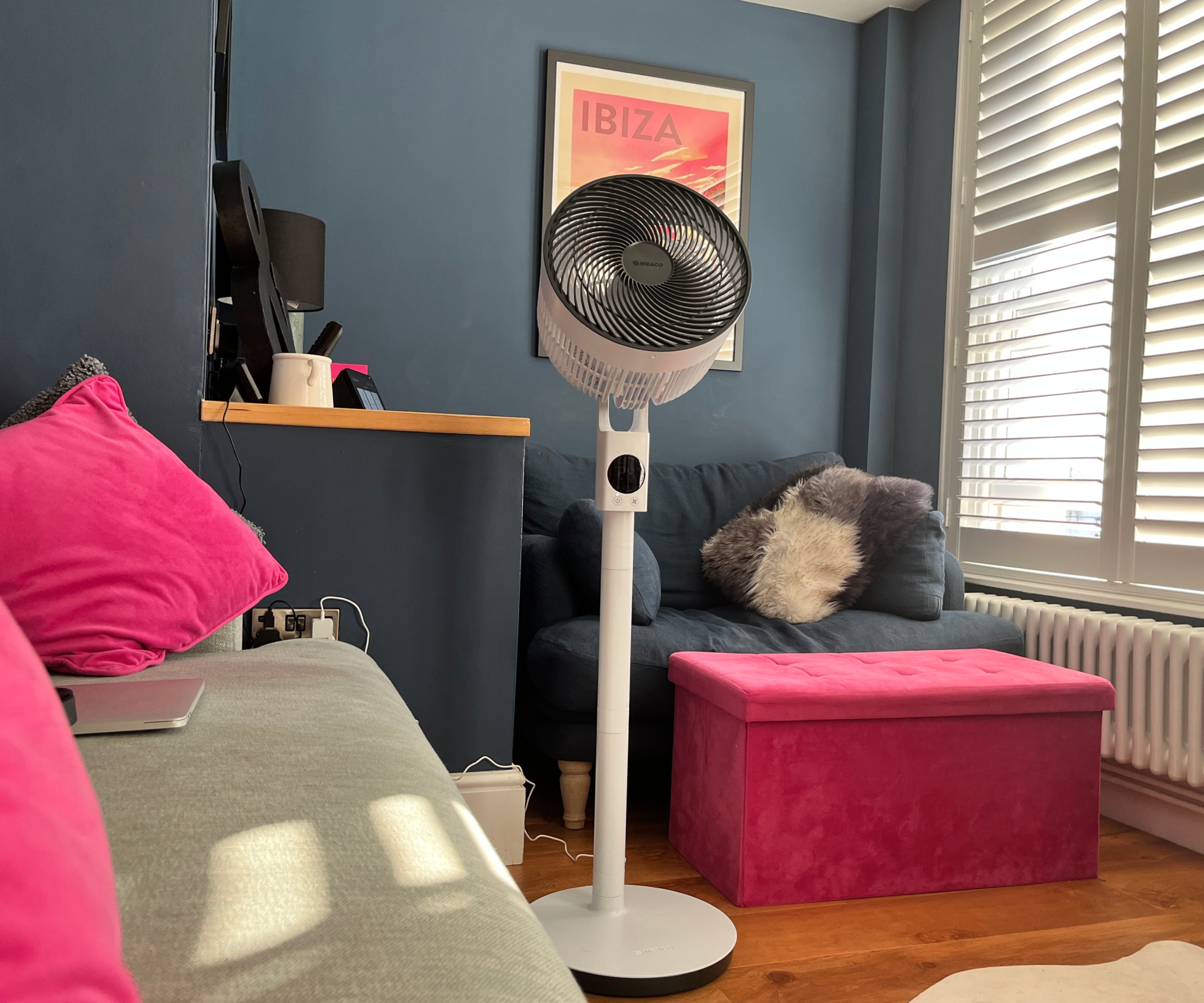 MeacoFan Sefte 10" Pedestal Air Circulator in living room with blue painted walls, blue chair, pink footstool, pale blue sofa with cushions