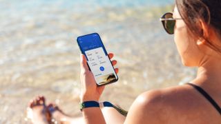 woman at beach holding phone