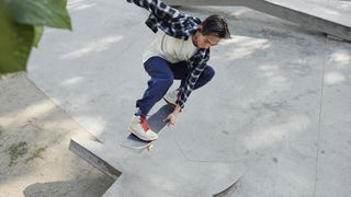Skater performing an ollie on his skateboard in an outdoor skatepark