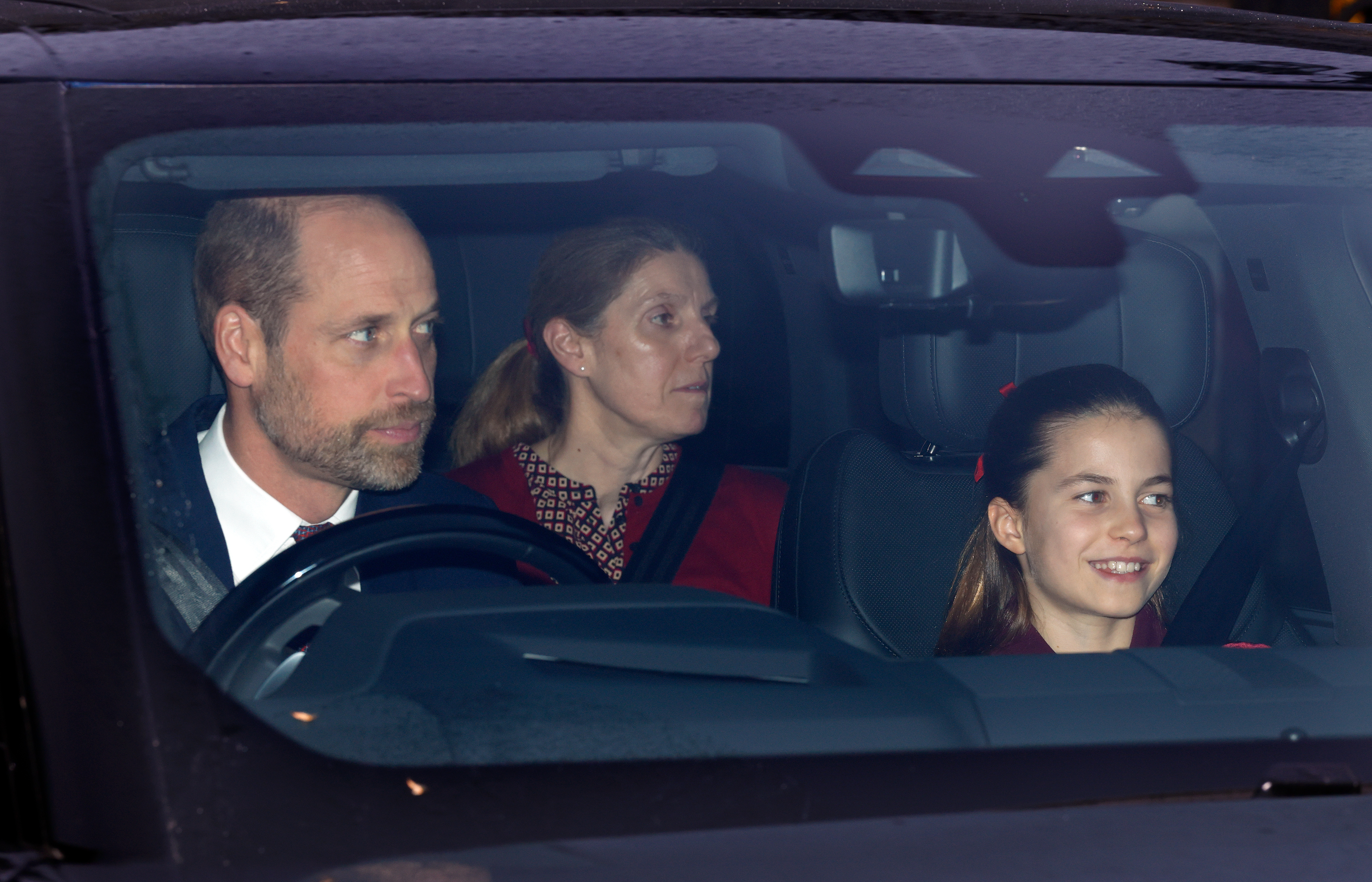 Prince William, Nanny Maria and Princess Charlotte driving in a car