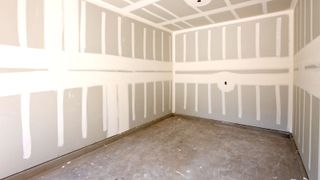 Single garage with grey concrete floor and plasterboard on walls and ceilings prepped for painting or plastering