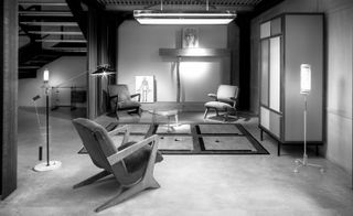 Design 'warehouse' showing three armchairs around a coffee table. There is a closet on the right wall. The photo is black & white.