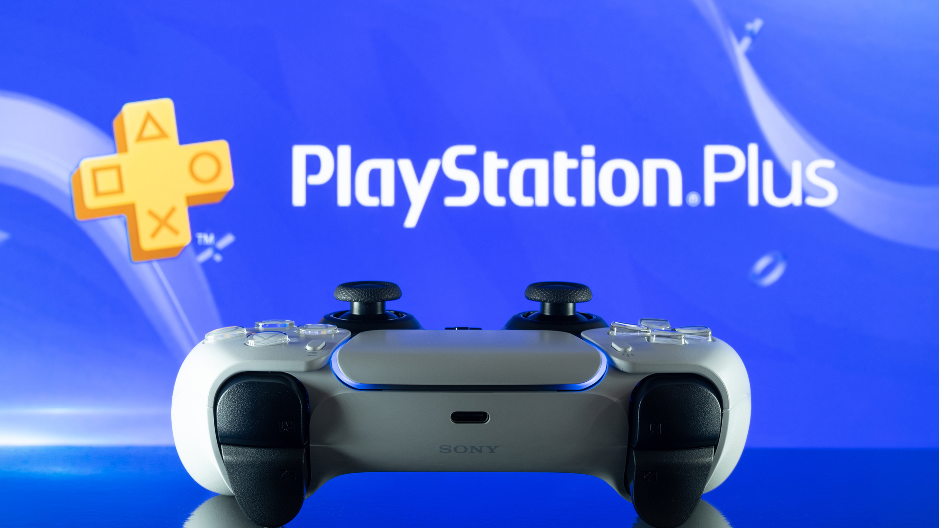 PlayStation Plus 로고 앞의 DualSense PS5 컨트롤러