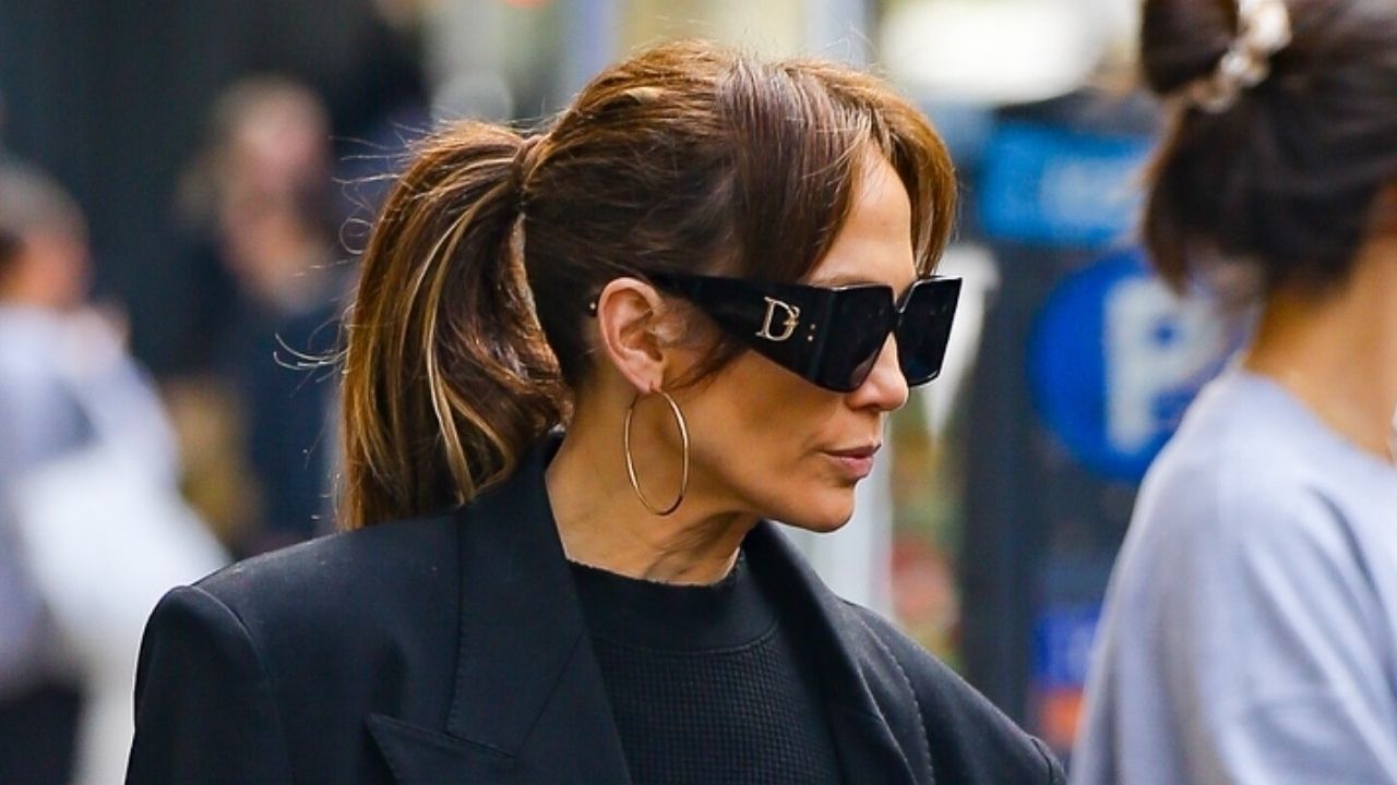 Jennifer Lopez in New York City April 2024 wearing a navy coat and sweater