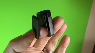 RØDE Wireless Micro microphone transmitter held in a hand in front of a green screen