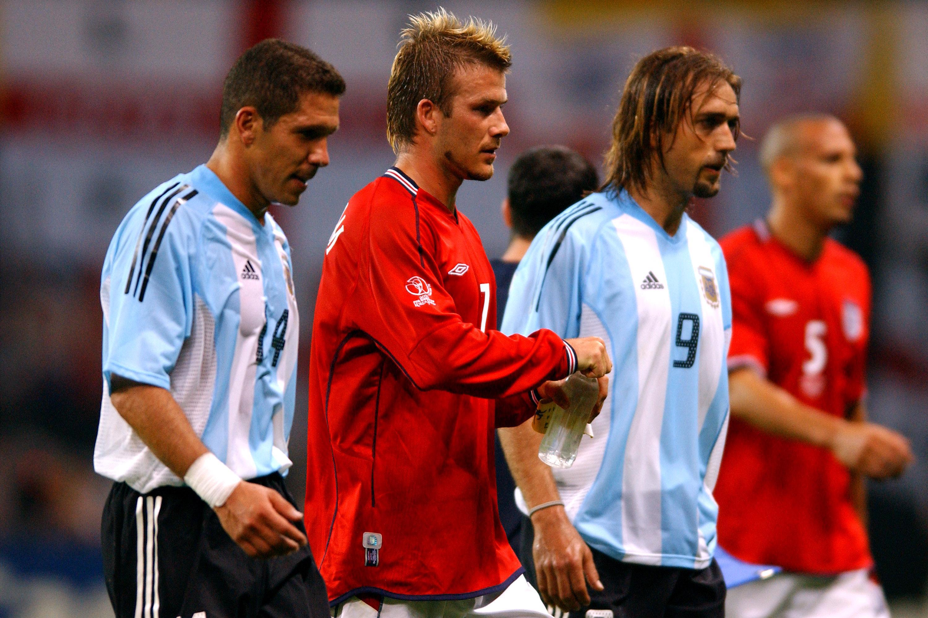 England captain David Beckham leaves the pitch at half-time of the 2002 World Cup group match against Argentina, alongside Diego Simeone and Gabriel Batistuta of Argentina, having given England the lead with a penalty