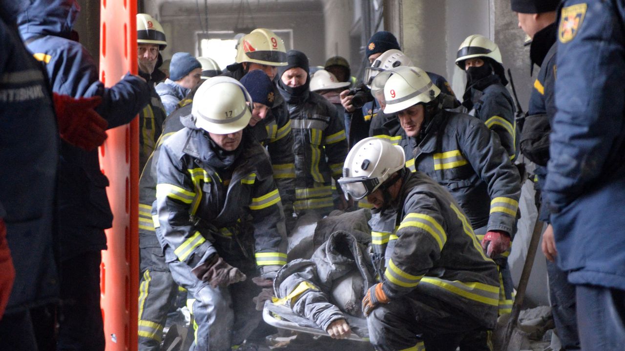 Ukrainian emergency services remove a person injured during shelling on Kharkiv City Hall 