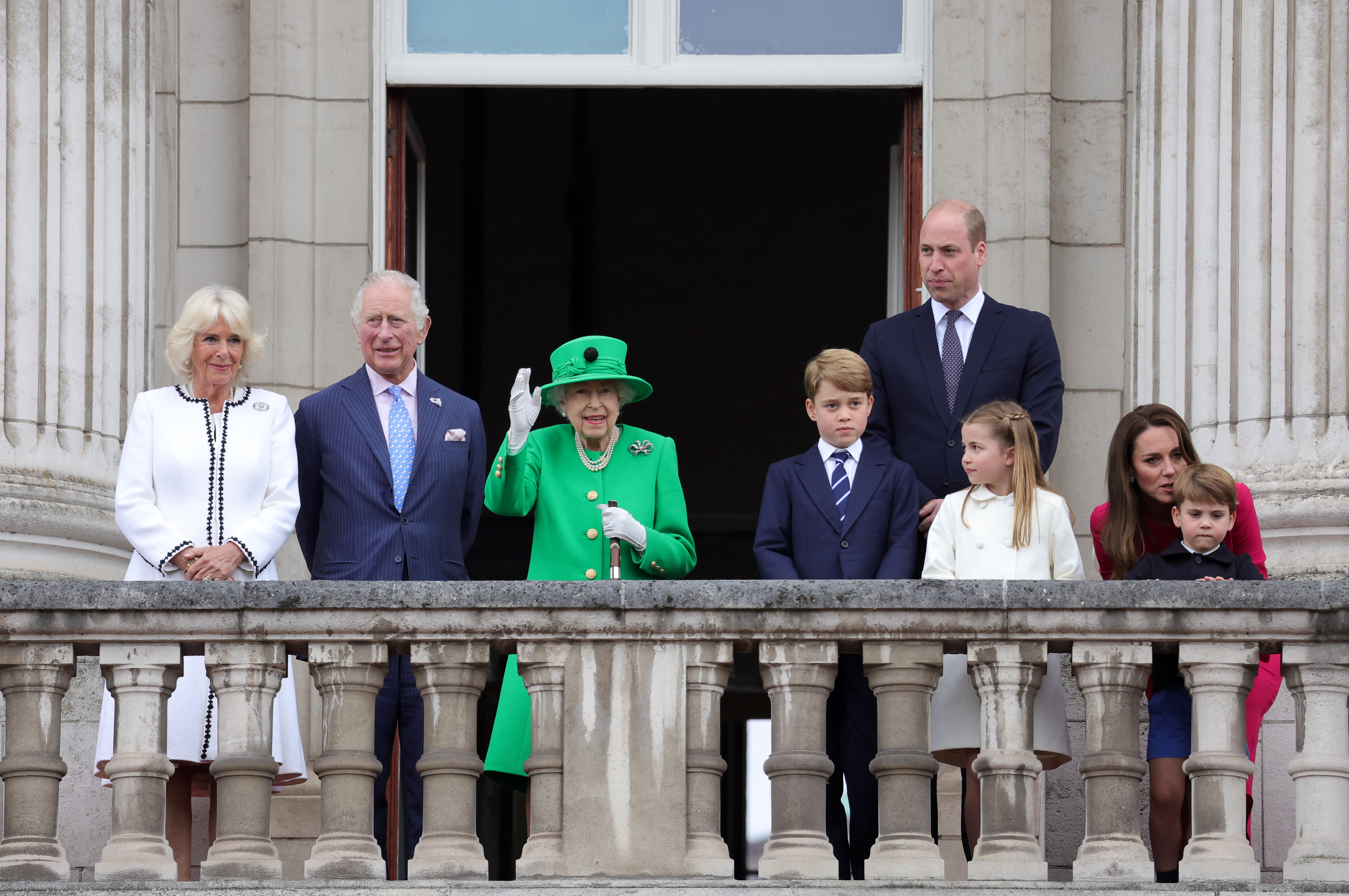 Queen Elizabeth waving on the balcony of Buckingham Palace with members of the Royal Family