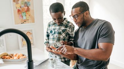 Dad teaching his son about money in the kitchen