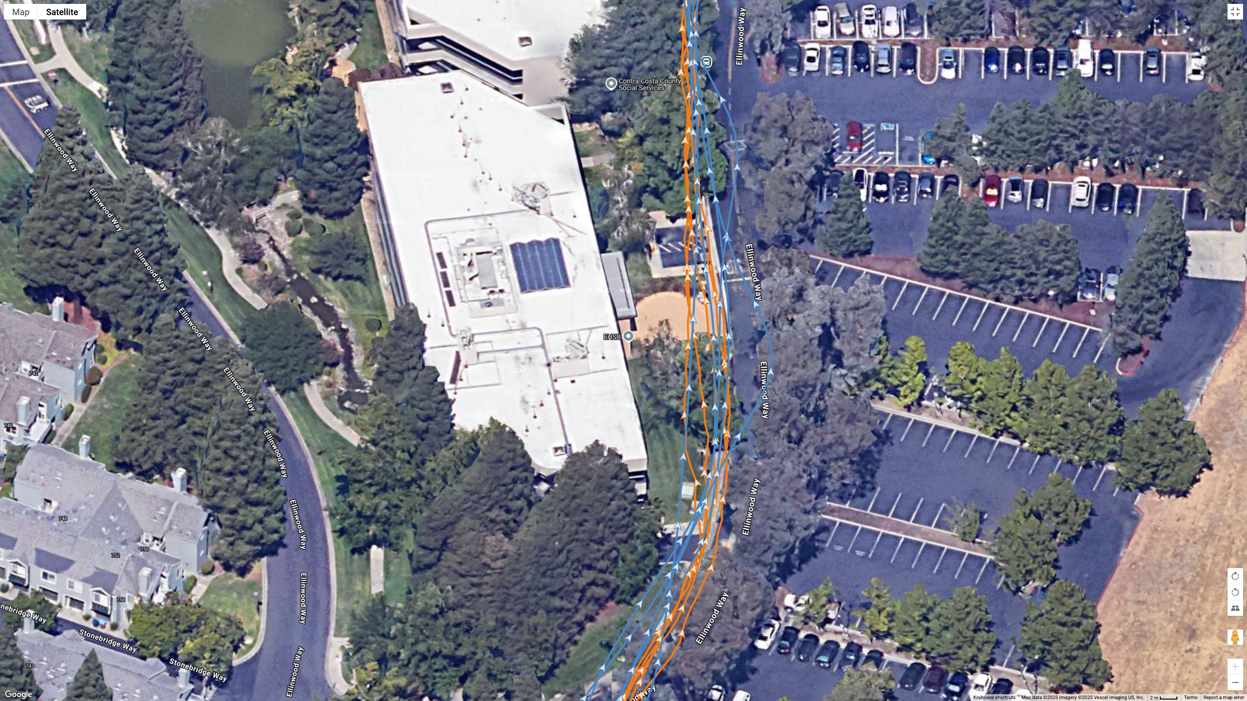 A Google Earth satellite map showing the GPS path of the Samsung Galaxy Watch 8 Classic (blue) and Garmin Forerunner 970 (orange) worn by the same runner.