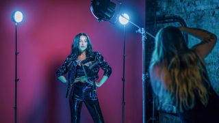 Rotolight LED lights being used for a studio shoot of femal model in a black suit with a purple backdrop