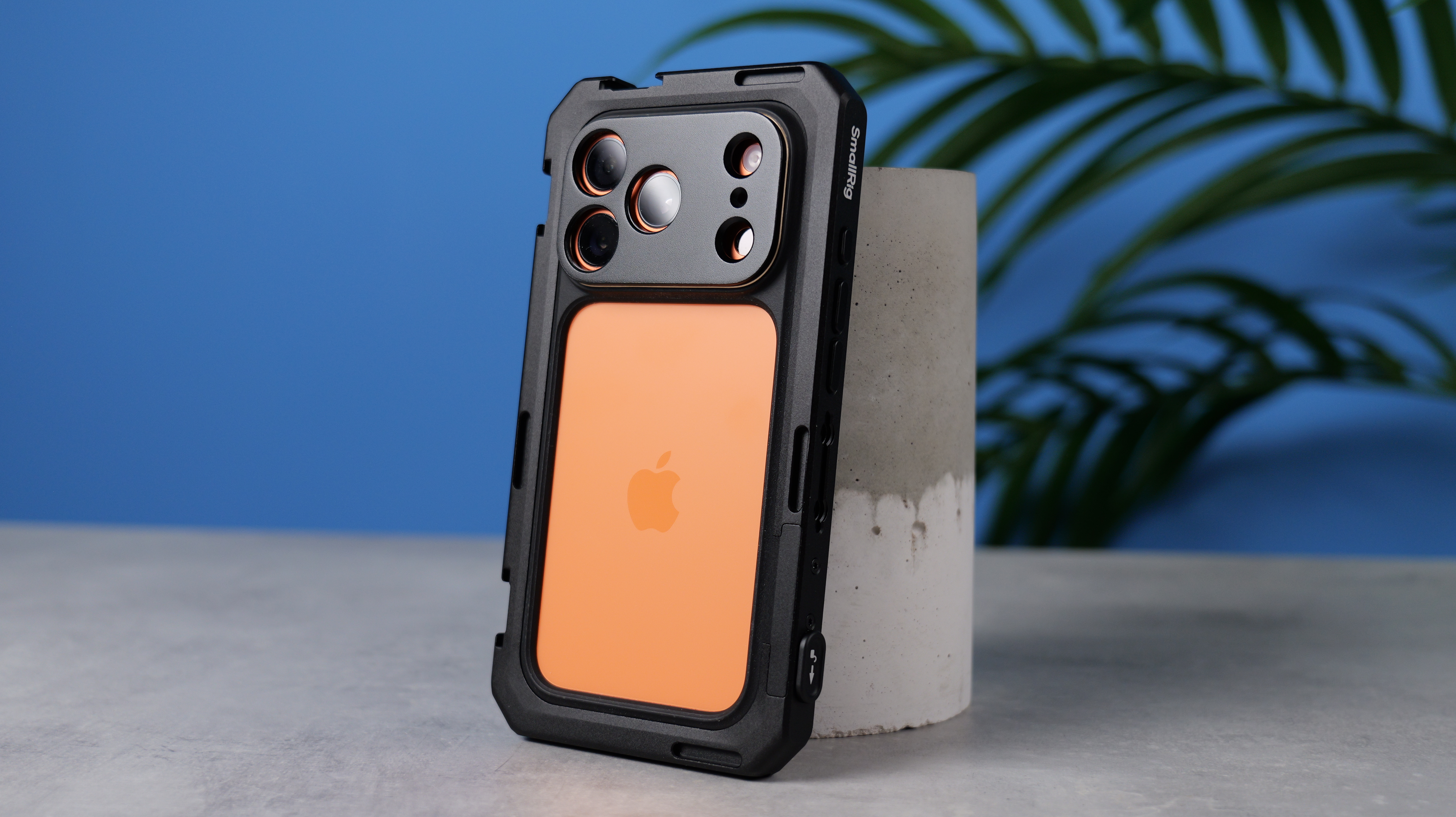 An orange iPhone 17 Pro encased within the SmallRig Universal iPhone cage