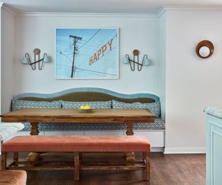 eat-in kitchen with banquette and wooden table and white walls