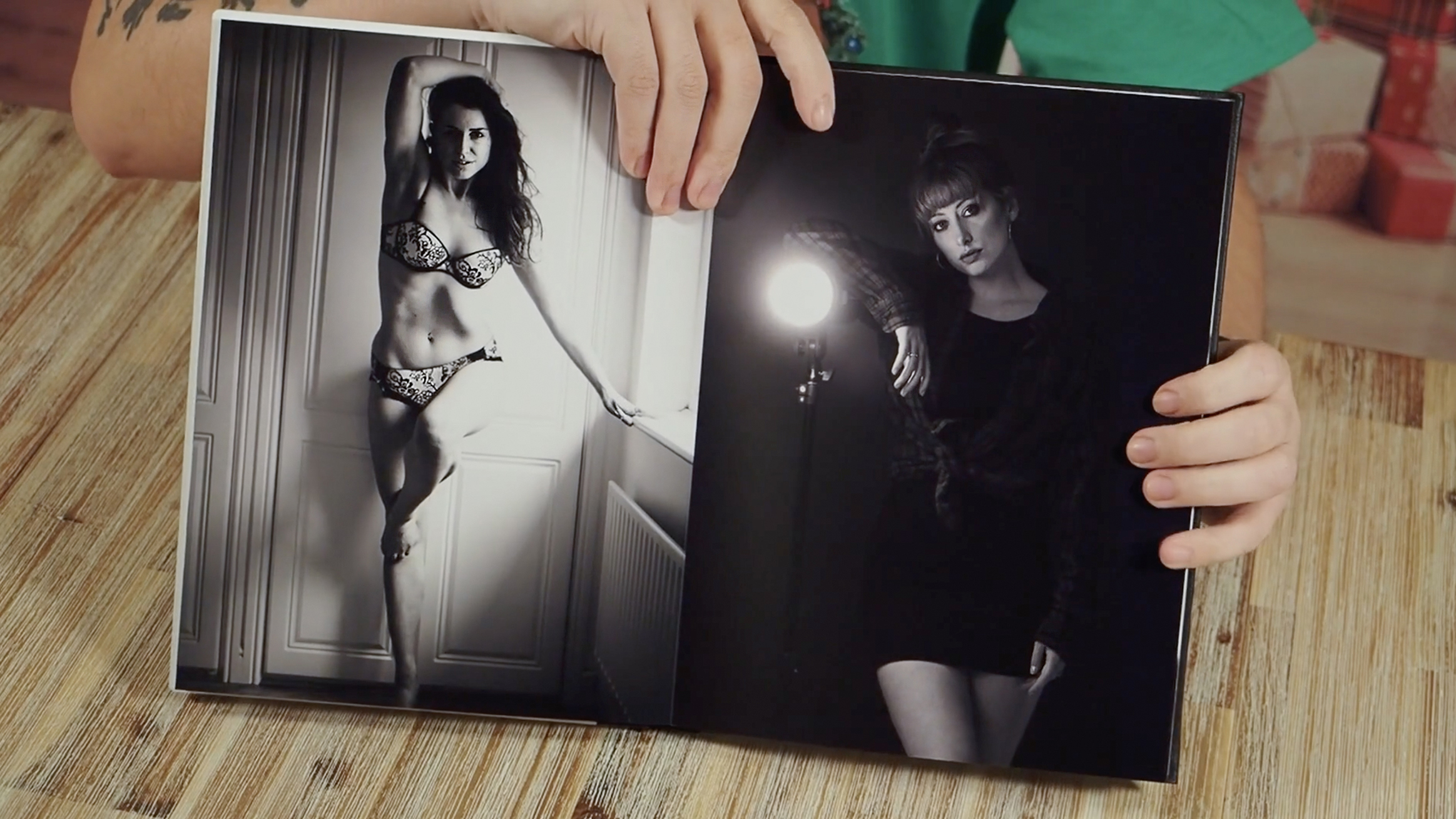 Photographer holding open a portfolio photobook, featuring female subjects