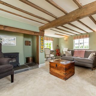 living room with wooden ceiling beams and grey sofa