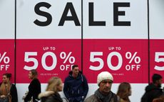 LONDON, ENGLAND - DECEMBER 30: People walk past a sale sign outside a department store on Oxford Street on December 30, 2015 in London, England. Shoppers are continuing to spend as stores off