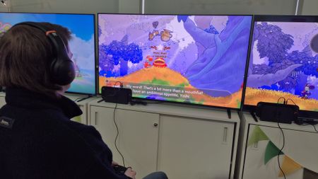 Over the shoulder image of man playing Yoshi and the Mysterious Book