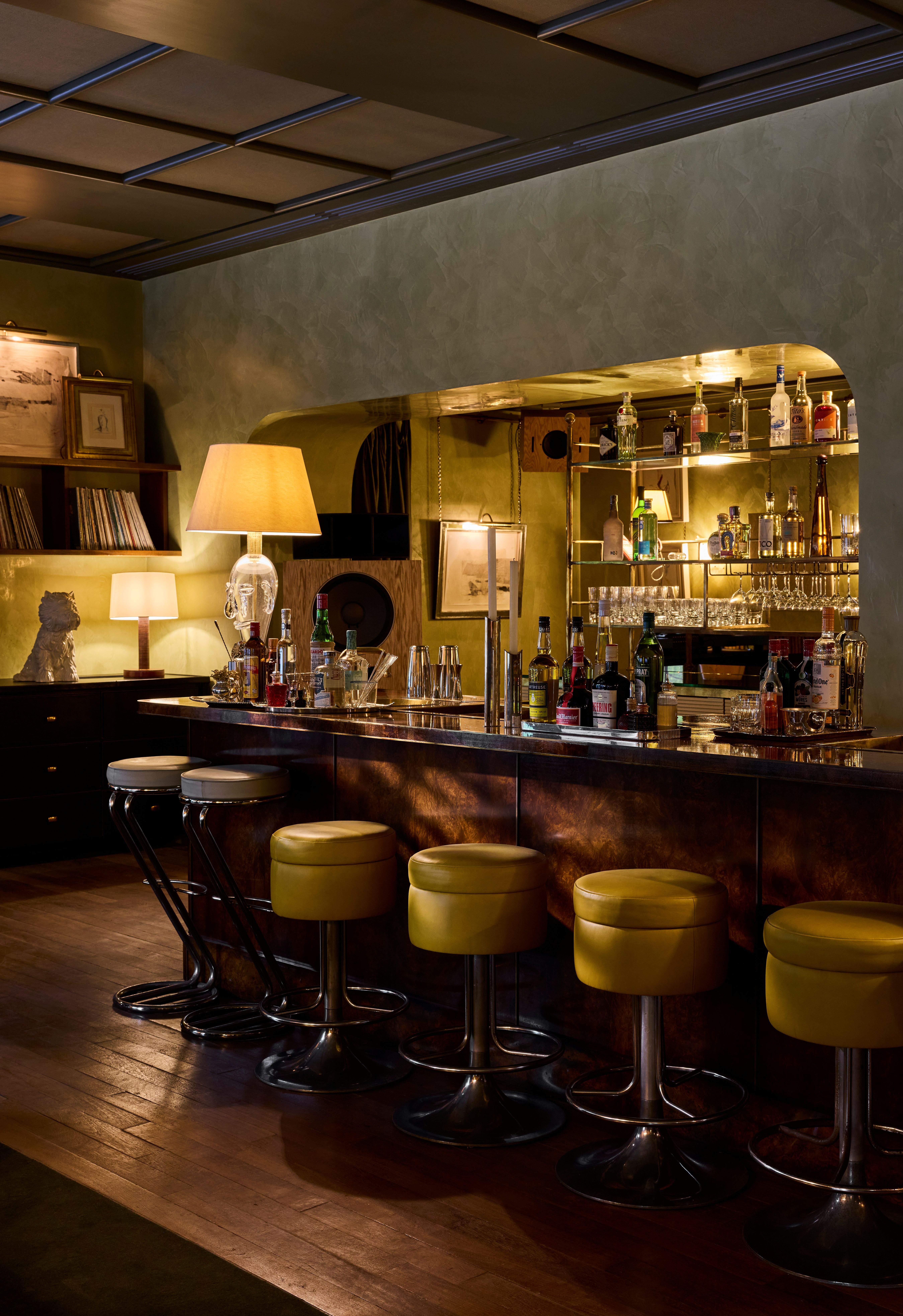 Intimate cocktail bar with wood panelling, low lighting and plush seating